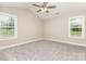 This is a bright, carpeted bedroom with a ceiling fan and two large windows at 115 Frances St, Salisbury, NC 28147