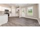 Modern kitchen with white cabinets, stainless steel appliances, granite countertops, and gray wood-look flooring at 115 Frances St, Salisbury, NC 28147