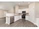 Well-lit kitchen with white cabinets, stainless steel appliances, granite countertops, and gray wood-look flooring at 115 Frances St, Salisbury, NC 28147