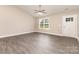 Bright living room featuring gray wood-look floors, a ceiling fan, and lots of natural light from the window at 115 Frances St, Salisbury, NC 28147