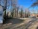 A tree-lined property shows a glimpse of a house and a parked vehicle, offering a secluded setting at 119 Lineberger St, Stanley, NC 28164