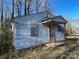 This cozy single-story home features a covered entry and weathered siding, offering a rustic charm at 119 Lineberger St, Stanley, NC 28164