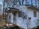 A weathered, white exterior corner of a house is seen with peeling paint and exposed electrical components at 119 Lineberger St, Stanley, NC 28164