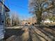 An open driveway leads to a brick home; another home is also visible among the trees at 119 Lineberger St, Stanley, NC 28164
