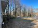 A home situated in a wooded area with a glimpse of the side, plus a driveway with vehicles at 119 Lineberger St, Stanley, NC 28164