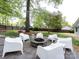 Backyard with a stone fire pit and modern seating, perfect for outdoor gatherings at 1310 Woodland Dr, Charlotte, NC 28205