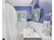 Cozy blue and white bathroom featuring a shower with a curtain and a round mirror at 1310 Woodland Dr, Charlotte, NC 28205