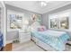 Bright bedroom featuring two large windows, a patterned comforter, and a white nightstand at 1310 Woodland Dr, Charlotte, NC 28205