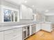 Sunlit kitchen features granite countertops, white cabinets, wine cooler, and stainless steel appliances at 1310 Woodland Dr, Charlotte, NC 28205