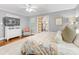 Spacious primary bedroom with gray walls, light carpet, ceiling fan, and access to the bathroom at 1310 Woodland Dr, Charlotte, NC 28205