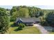 An aerial view shows the blue house with a gray roof, a front porch, and lush surrounding greenery at 139 Fort Dobbs Rd, Statesville, NC 28625