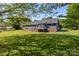 A view of the home's backyard with a deck, green lawn, siding exterior, and brick foundation at 139 Fort Dobbs Rd, Statesville, NC 28625