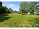 Backyard featuring a green lawn, a deck, trees, siding exterior, and a brick foundation at 139 Fort Dobbs Rd, Statesville, NC 28625