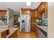 Kitchen with stainless steel refrigerator, granite counters, sink, and view to living room at 139 Fort Dobbs Rd, Statesville, NC 28625