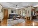 Bright living room featuring a leather sofa, area rug, and natural light from the windows at 139 Fort Dobbs Rd, Statesville, NC 28625