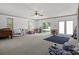 Spacious, carpeted living room features many windows, sliding doors, and ceiling fan for comfortable living at 139 Fort Dobbs Rd, Statesville, NC 28625