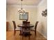 Elegant dining room with wood floors, chandelier, and a round dining table with four chairs at 14022 Drake Watch Ln, Charlotte, NC 28262