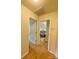 Hallway featuring wood floors, white trim, and two doorways leading to different rooms at 14022 Drake Watch Ln, Charlotte, NC 28262