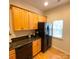 The kitchen features a black refrigerator, granite countertops and wooden cabinets at 14022 Drake Watch Ln, Charlotte, NC 28262