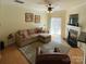 Inviting living room features hardwood floors, fireplace, a ceiling fan, and sliding glass doors to patio at 14022 Drake Watch Ln, Charlotte, NC 28262