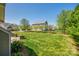Beautiful backyard featuring a green lawn, well-maintained landscaping, and mature trees at 14905 Skyscape Dr, Huntersville, NC 28078