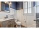Stylish half bathroom features modern fixtures, wood-look vanity, and elegant paneling at 14905 Skyscape Dr, Huntersville, NC 28078