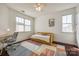 Bright bedroom featuring two windows, a stylish rug, and a cozy daybed with a yellow frame at 14905 Skyscape Dr, Huntersville, NC 28078
