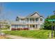 Charming two-story home boasts a welcoming front porch and balcony, nestled on a well-manicured lawn at 14905 Skyscape Dr, Huntersville, NC 28078