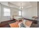 Elegant main bedroom featuring a tray ceiling, a modern light fixture, and decorative wall paneling at 14905 Skyscape Dr, Huntersville, NC 28078