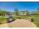 An outdoor brick patio featuring a stone grill, perfect for entertaining in a lush backyard setting at 14905 Skyscape Dr, Huntersville, NC 28078