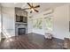 This sunroom features a brick fireplace, ceiling fan, dark wood floors, and lots of natural light at 14905 Skyscape Dr, Huntersville, NC 28078