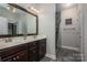 Bathroom featuring a double vanity with dark wood cabinets, modern fixtures, and a tiled walk-in shower at 2001 Cramer Place Ct, Cramerton, NC 28032