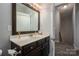 This bathroom features a wood framed mirror, dark wood vanity, white countertops and fixtures at 2001 Cramer Place Ct, Cramerton, NC 28032