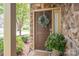 Stylish front door featuring a decorative wreath, potted plant, and stone accents creating an inviting entryway at 2001 Cramer Place Ct, Cramerton, NC 28032