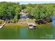 Beautiful aerial shot of a lakeside house with a private dock, lush trees and lawns at 2045 Manila Bay Ln, Tega Cay, SC 29708