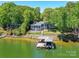 Lakeside home featuring a private dock, boathouse, outdoor space, and lush surroundings at 2045 Manila Bay Ln, Tega Cay, SC 29708