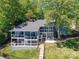 Rear view of a two-story home with large deck, lush lawn and tiered landscaping at 2045 Manila Bay Ln, Tega Cay, SC 29708