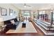 Open concept living room with ample seating, hardwood floors, and seamless flow into the dining area with lake views at 2045 Manila Bay Ln, Tega Cay, SC 29708