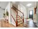 Spacious foyer features beautiful wood flooring, a staircase, and a view to the front door at 2065 Taney Way, Indian Land, SC 29707