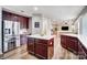 Open concept kitchen with stainless steel appliances, wood cabinets, quartz countertops, and hardwood floors at 2065 Taney Way, Indian Land, SC 29707