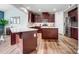 Modern kitchen featuring dark wood cabinets, quartz countertops, hardwood floors, and stainless steel appliances at 2065 Taney Way, Indian Land, SC 29707