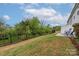 Lush backyard with a black metal fence, well-maintained lawn, and a cozy patio set at 23112 Clarabelle Dr, Charlotte, NC 28273