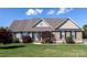 Charming home with a combination of stone and siding, manicured lawn, and inviting front porch at 234 Deal Estate Dr, China Grove, NC 28023