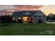 Attractive home with stone accents, manicured lawn, and inviting entryway at dusk at 234 Deal Estate Dr, China Grove, NC 28023