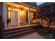 Inviting front porch with brick steps, swing, and decorative plants, creating a welcoming entrance at 234 Deal Estate Dr, China Grove, NC 28023