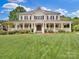 Stately two-story home with a charming wrap-around porch, manicured lawn, and classic curb appeal at 2553 Fallbrook Nw Pl, Concord, NC 28027