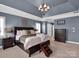 Cozy main bedroom with a tray ceiling, sitting area, and soft, neutral tones at 2553 Fallbrook Nw Pl, Concord, NC 28027