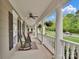 Spacious wrap-around porch with rocking chairs, ceiling fans, and elegant columns offering a relaxing outdoor retreat at 2553 Fallbrook Nw Pl, Concord, NC 28027