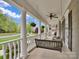Charming wrap-around porch featuring a swing, rocking chairs, and views of the neighborhood at 2553 Fallbrook Nw Pl, Concord, NC 28027