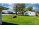 Spacious backyard with lush green grass, mature trees, and a charming brick fire pit at 2701 N Main Ave, Newton, NC 28658